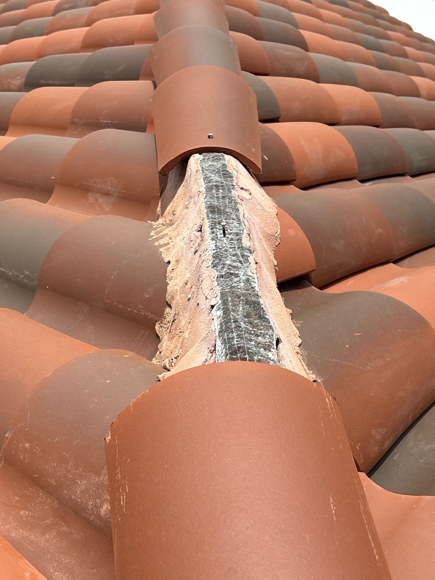 Ridge cap detail work on clay tile roof